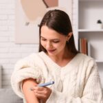 Woman checking blood sugar levels at home as part of pre-diabetes screening and diabetes prevention