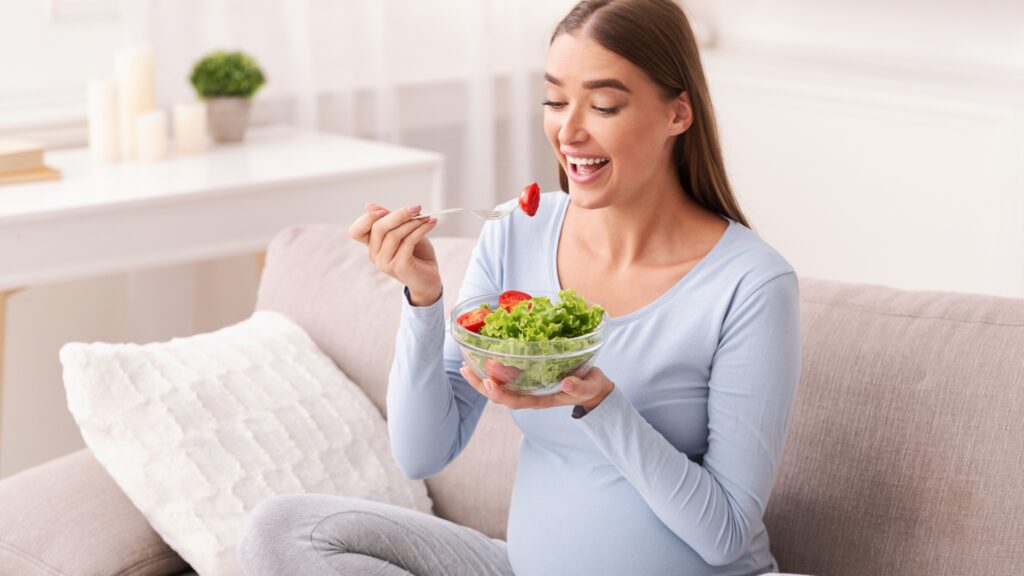 Pregnant woman eating healthy food at home during pregnancy for balanced trimester-wise nutrition