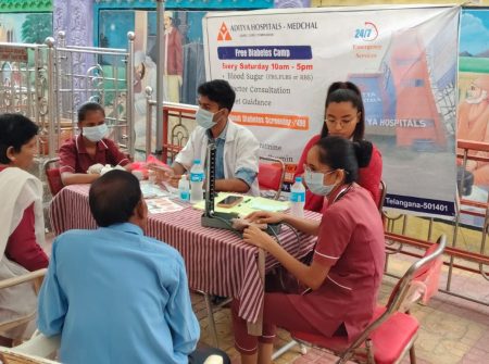 Medical team providing diabetes consultation and glucose testing at health camp